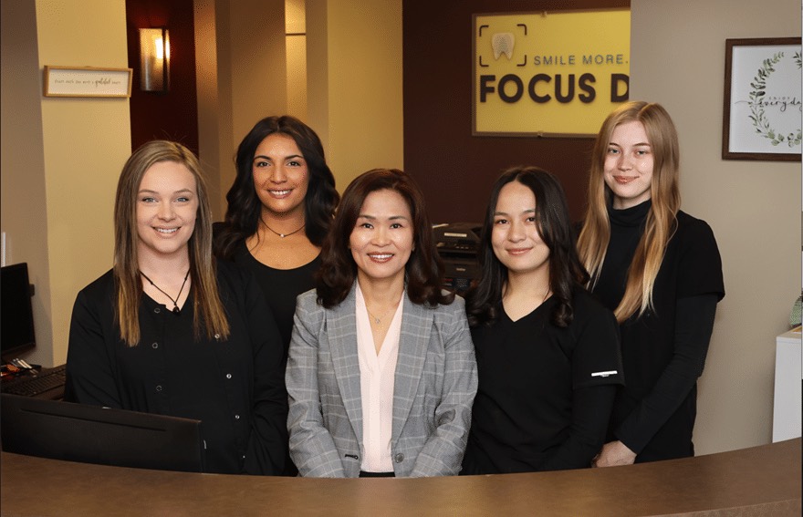 Dr. Misook Rissler and the Focus Dental Studio team smiling together at the front desk